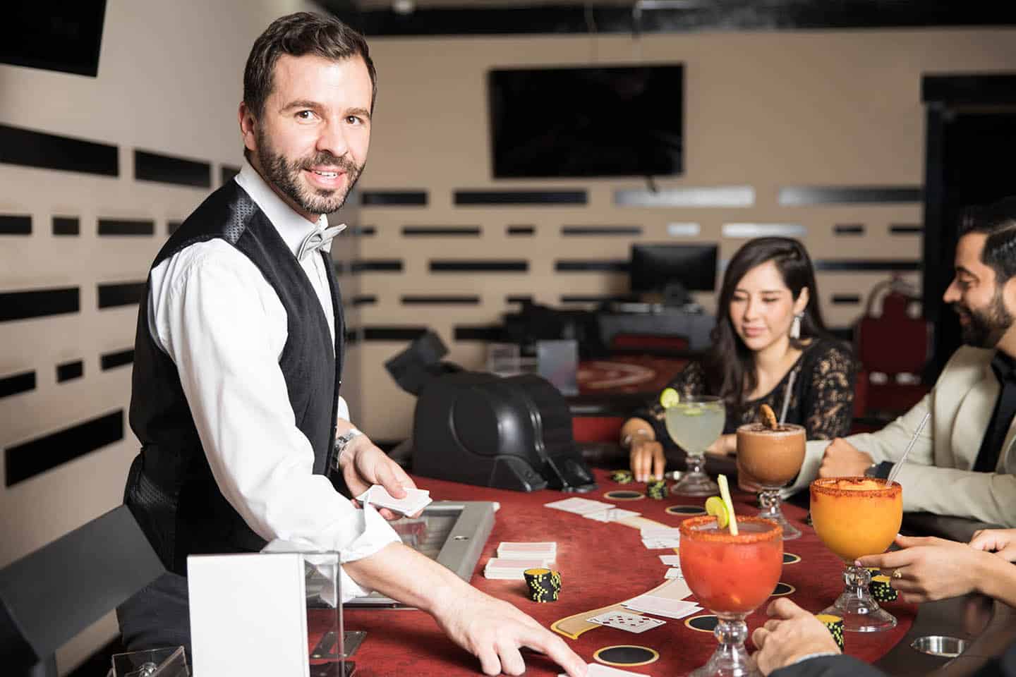 Portrait of a handsome Hispanic card dealer playing blackjack in a casino
