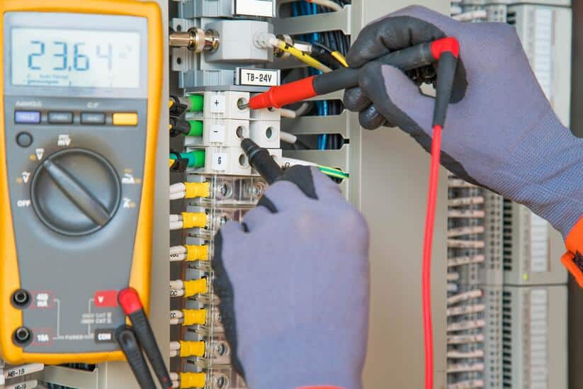Worker with PPE gloves testing electricity voltage