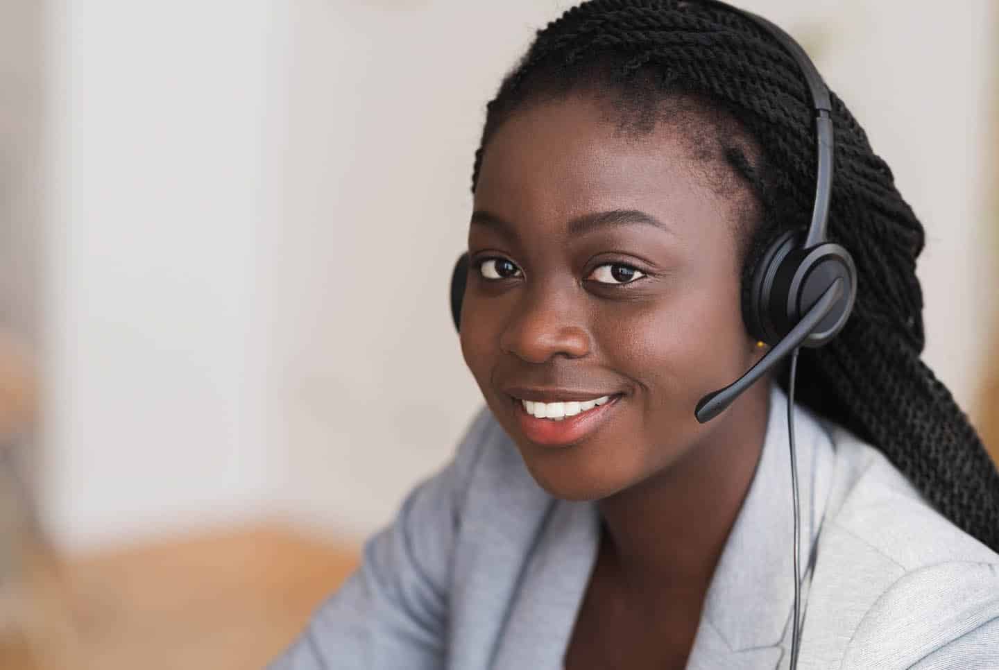 Hotline operator. Portrait of beautiful black female customer service manager wearing headset while working in call center