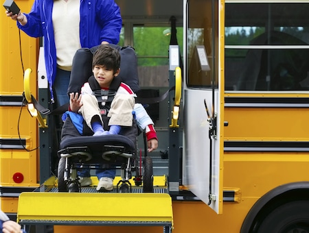 Disabled five year old boy using a wheelchairbus lift