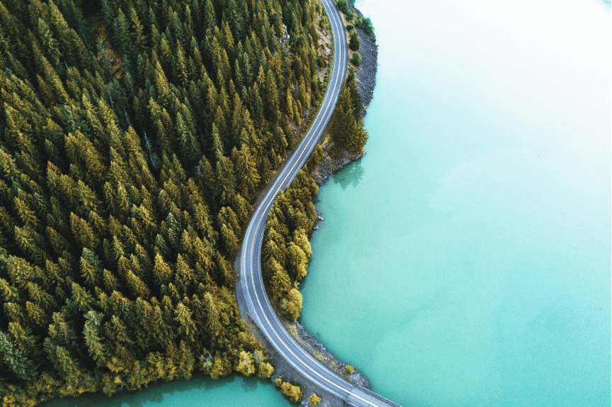 Aerial forest and ocean shot with road