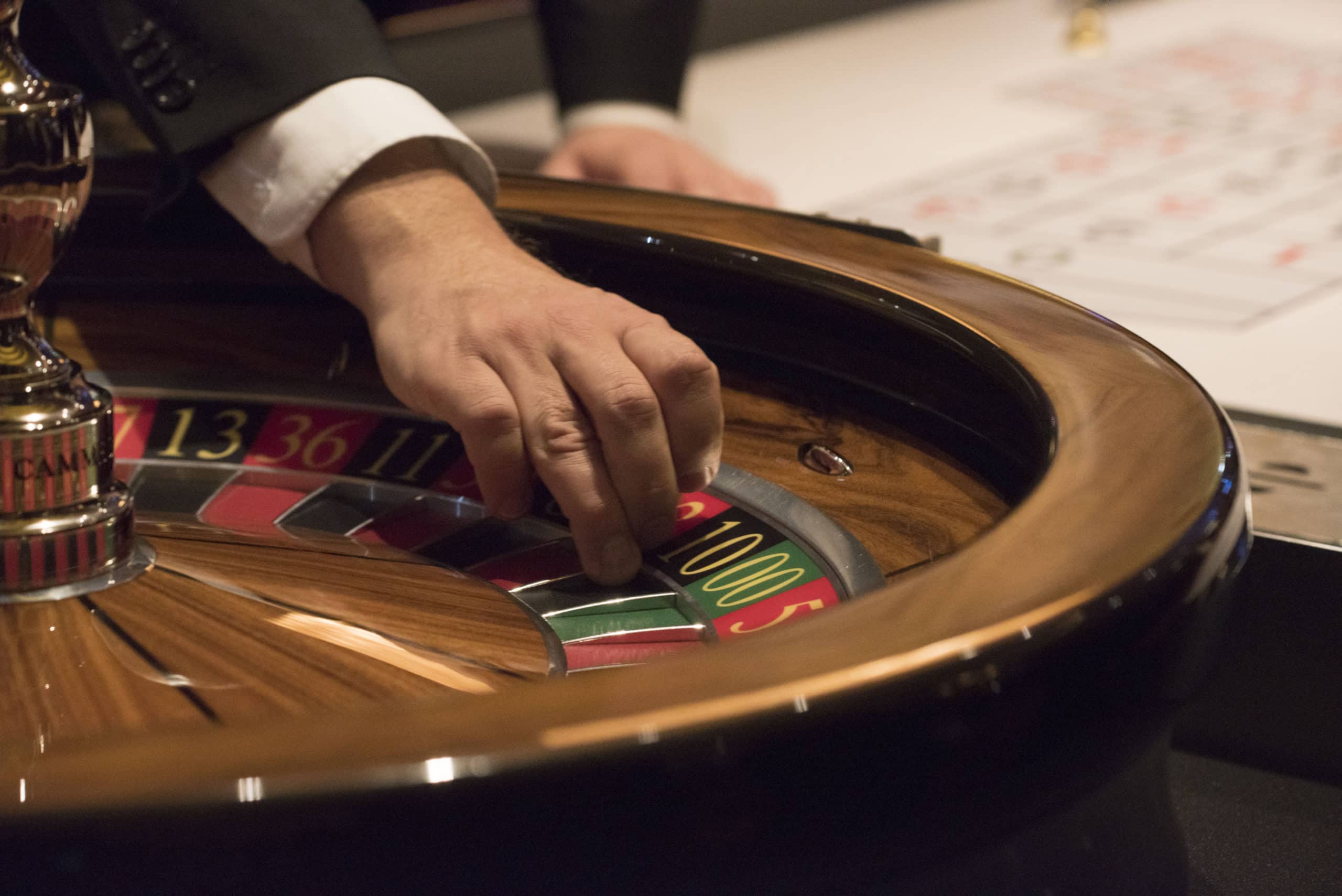 hand grabbing dice on roulette table