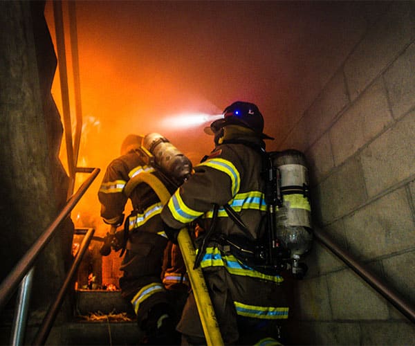 Firefighters training with hose on stairs