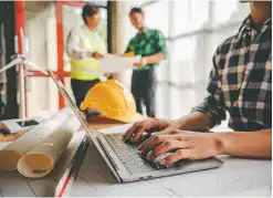 Man working on a laptop at a construction site