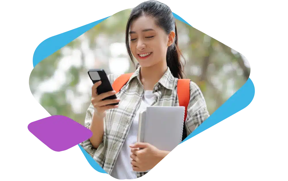 Student with a backpack holding a book in one hand and a phone in another