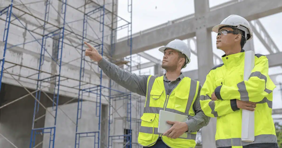 2 construction workers reviewing worksite with safety software