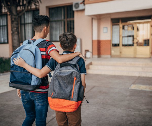 Two students hugging as they walk to school
