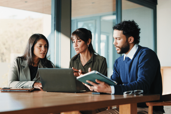 A group of smiling college professors reviewing reports