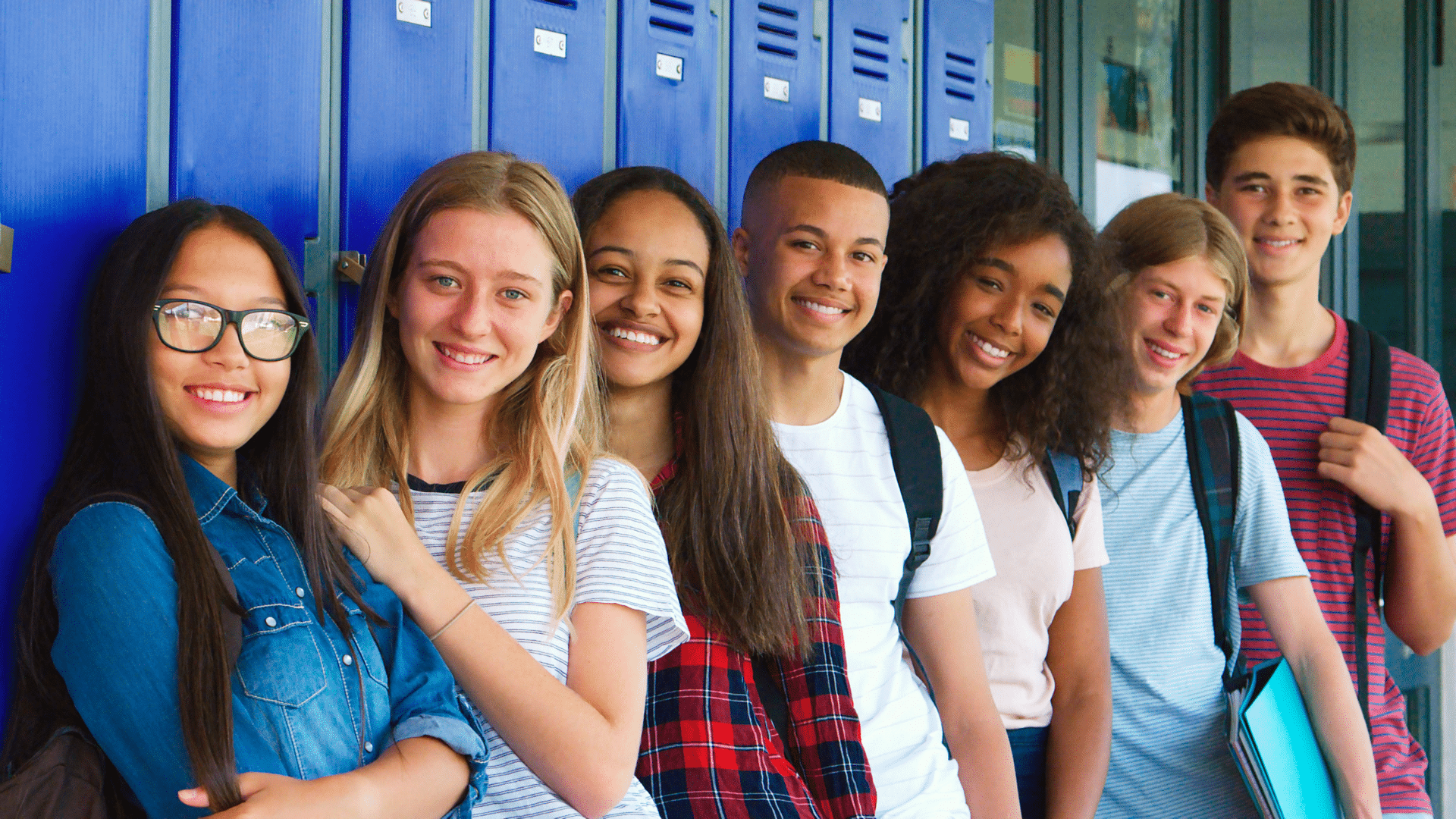 A group of high school students standing in front of a wall of lockers