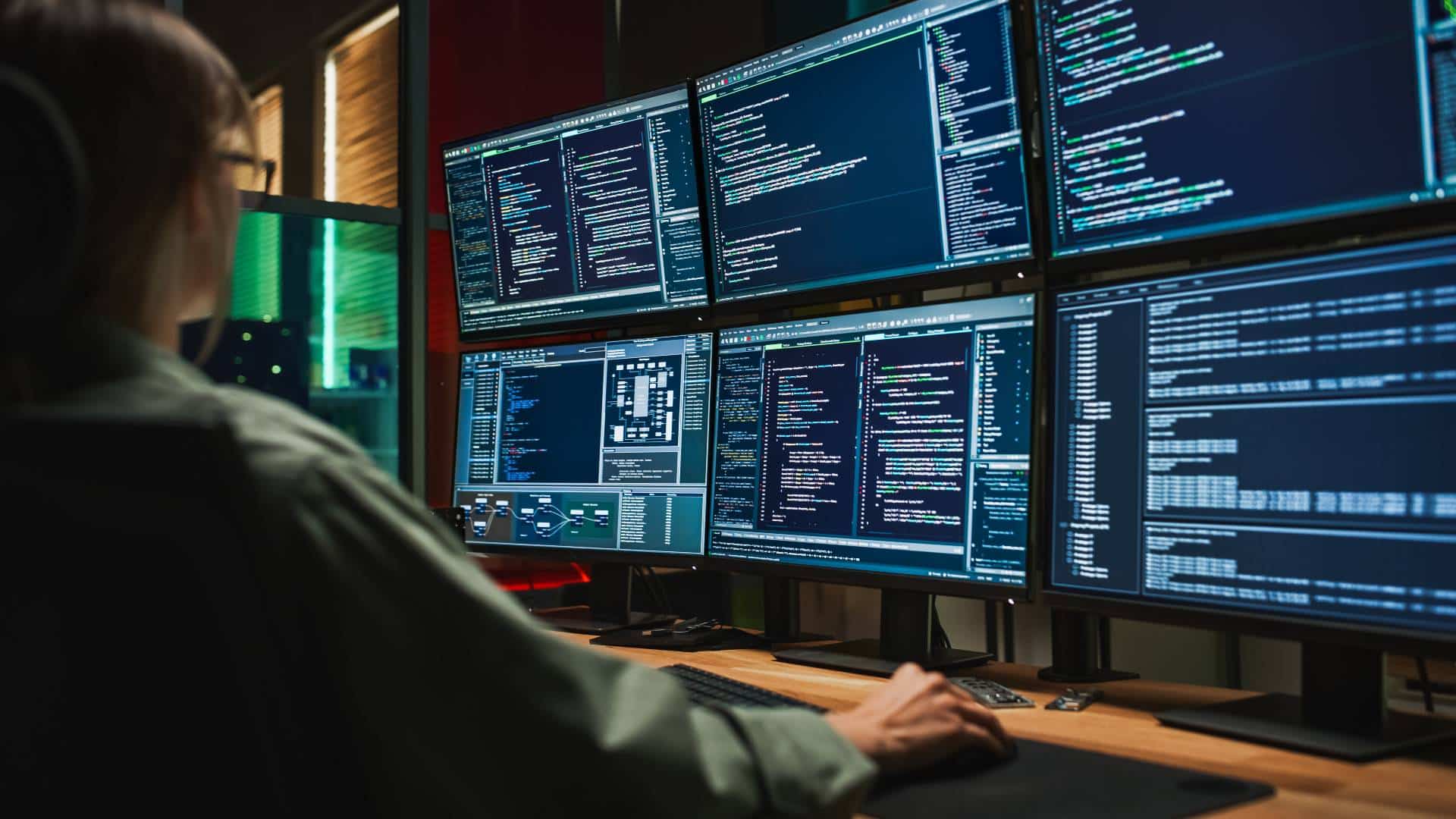 Emergency communications specialist monitoring multiple dispatch and data screens in a public safety operations center