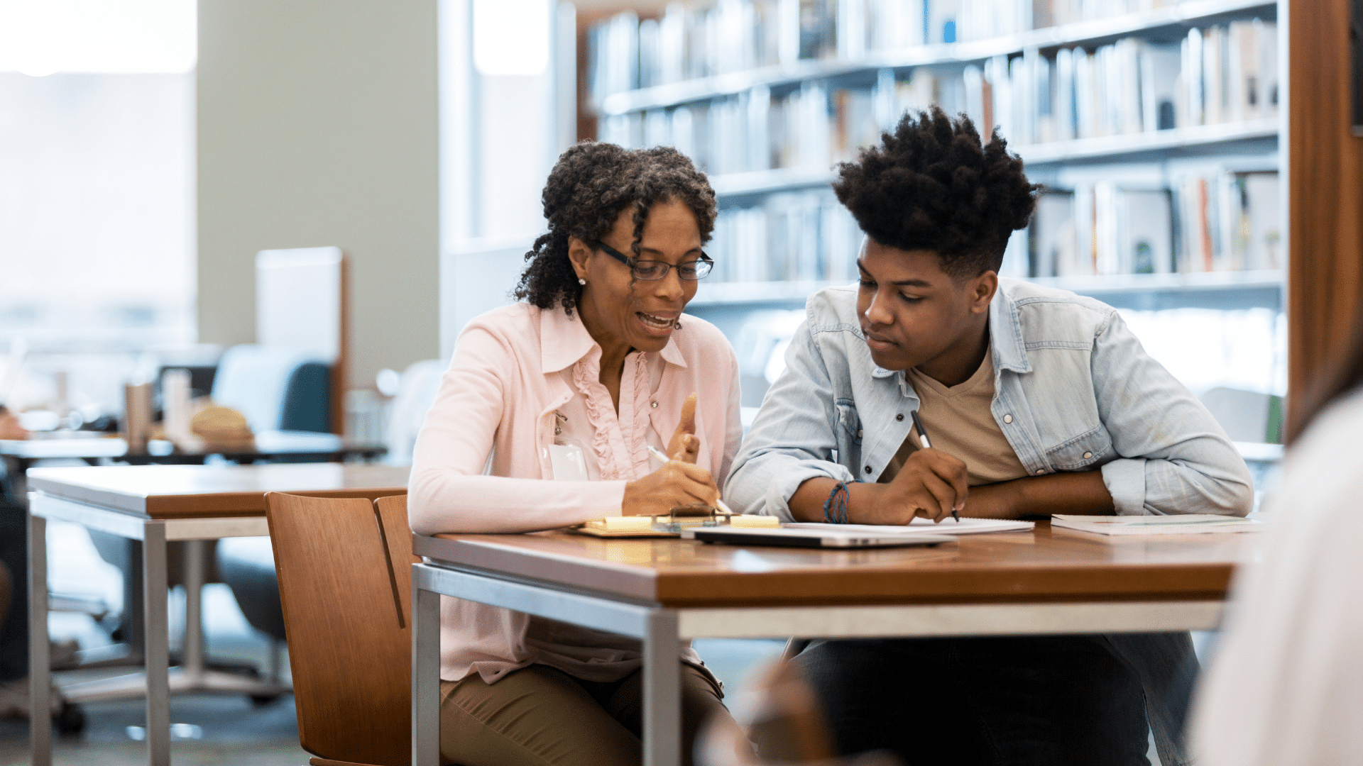 A K-12 teacher helping a student